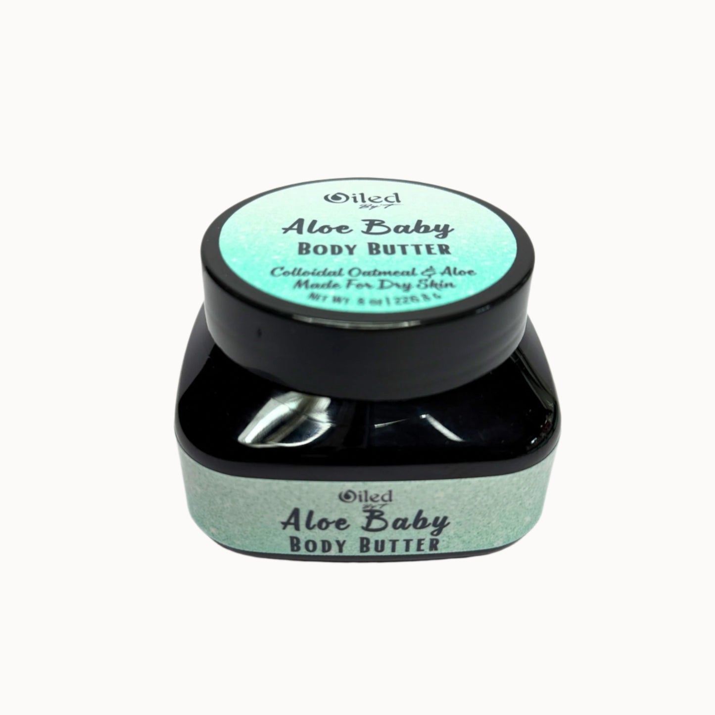 A jar of Aloe Baby Body Butter with a black lid on a light background, with the product name visible on the jar.