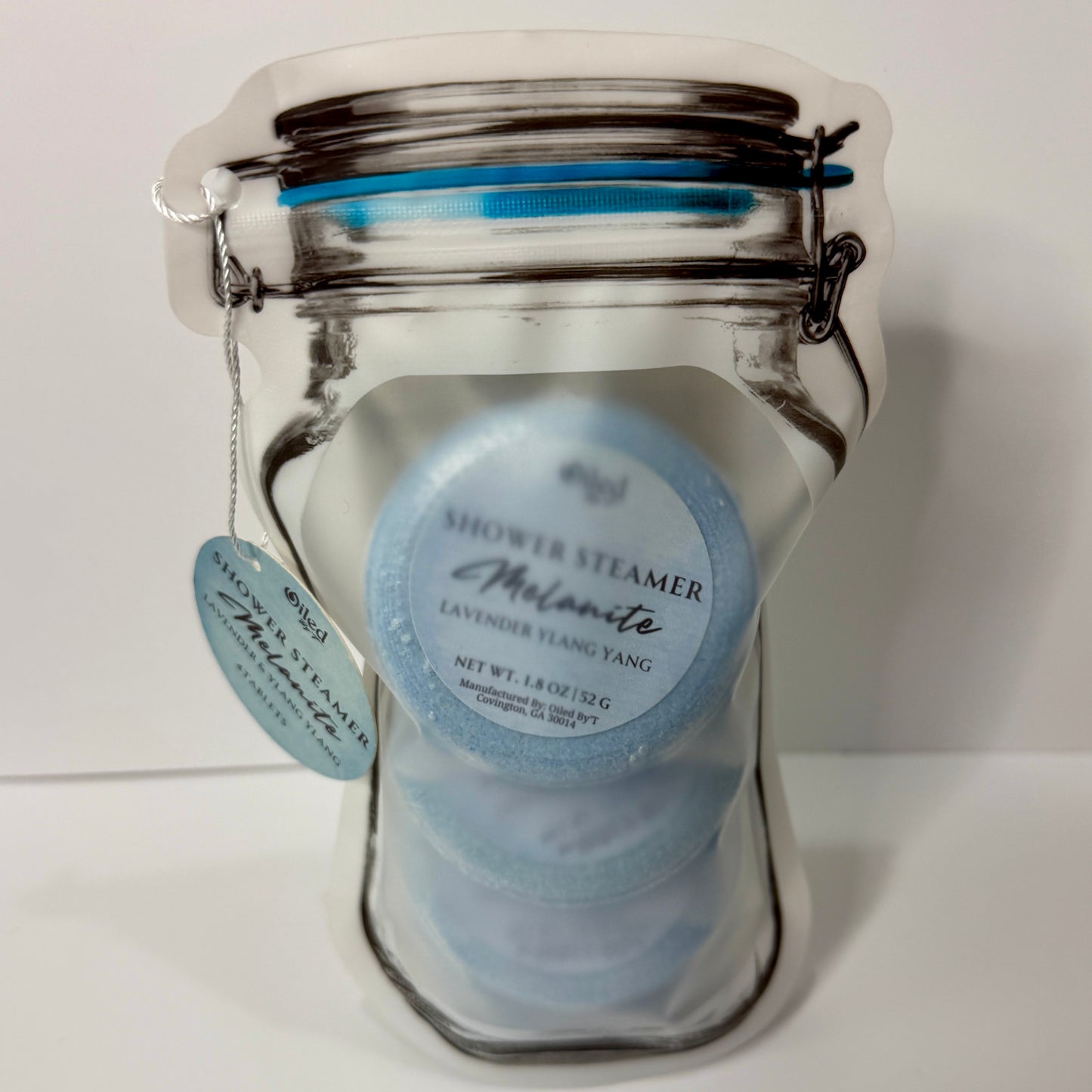 Plastic stand up pouch mason jar shape with four Melanite Shower Steamers inside on a white background
