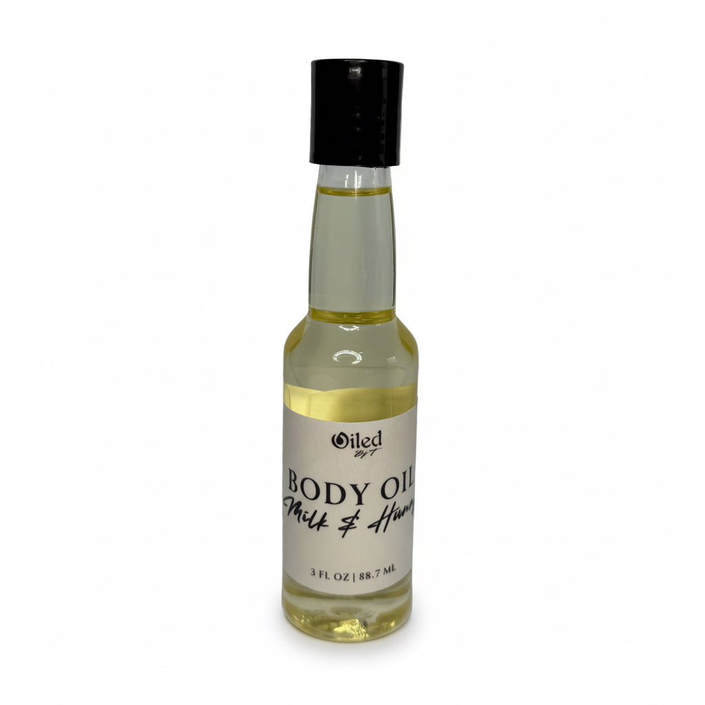 Bottle of body oil with a black cap on a white background