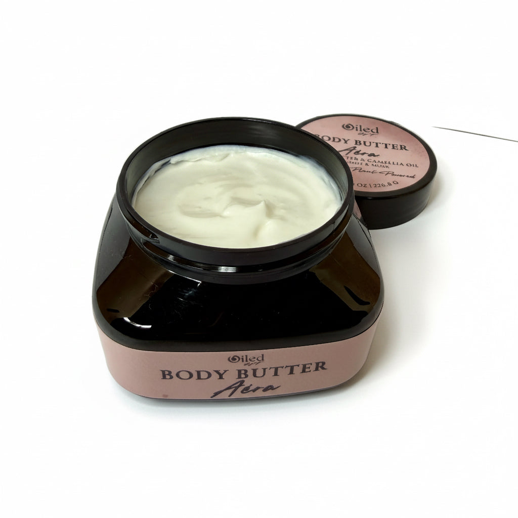 Jar of body butter with a black lid on a white surface