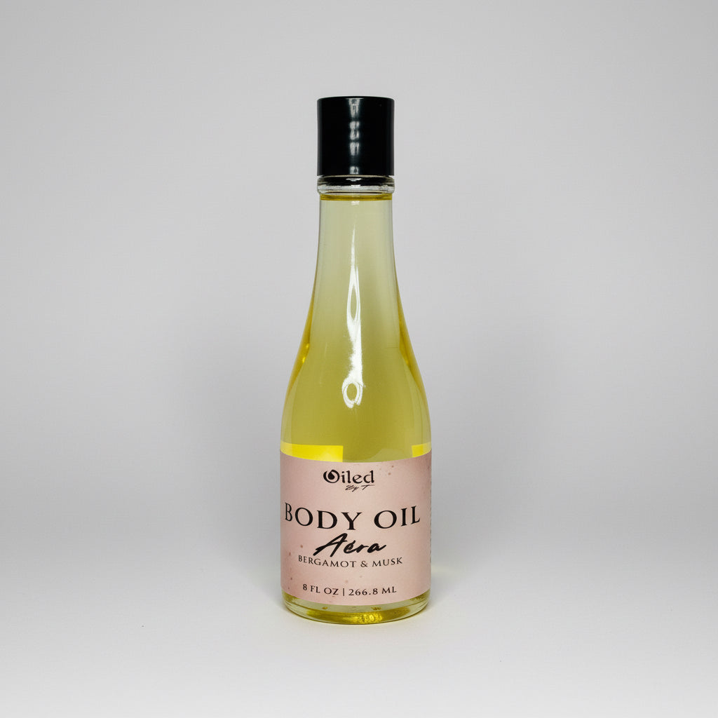 Bottle of body oil with a black cap on a light gray background