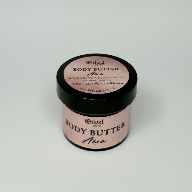 2 oz Jar of body butter with pink label and black lid on a white background
