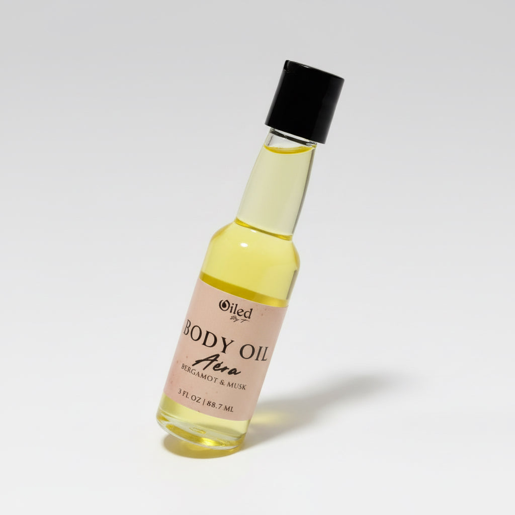 Bottle of body oil with a black cap on a white background