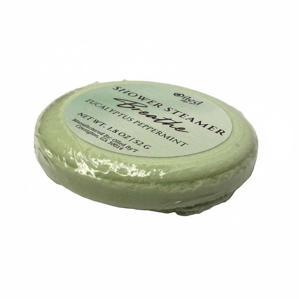 Green shower steamer with a label on a white surface