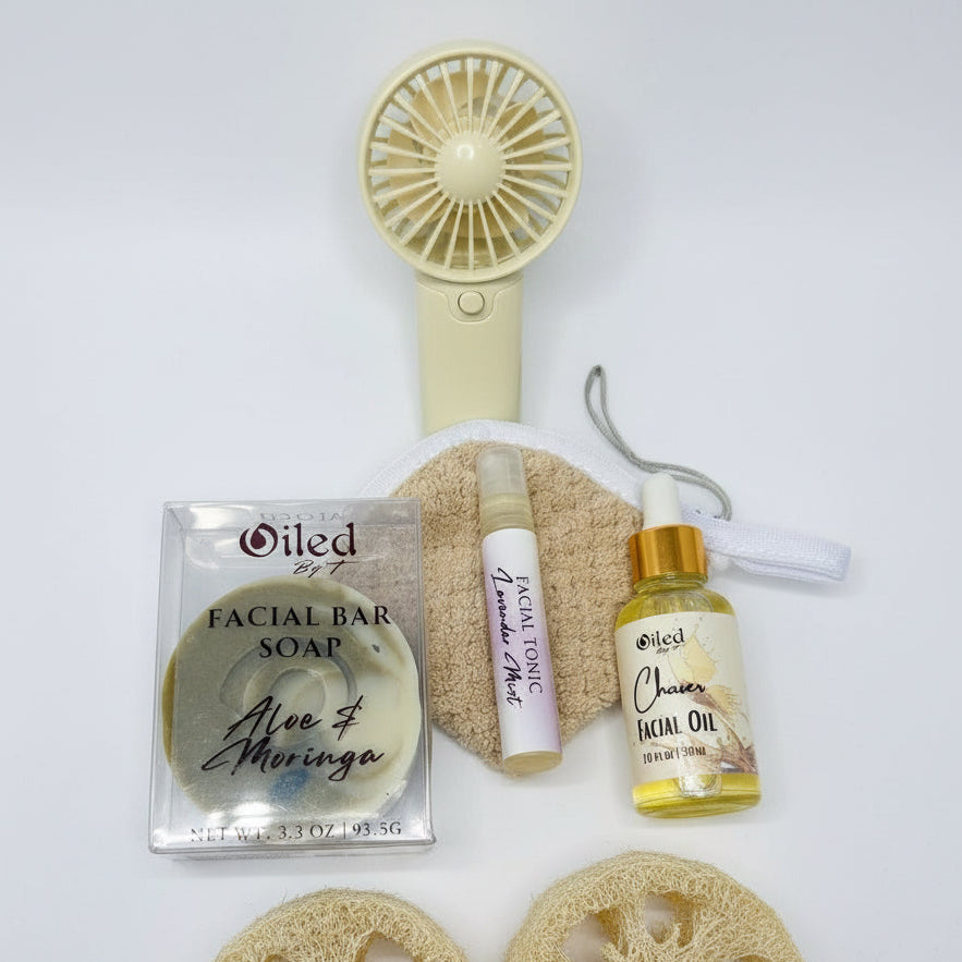 Collection of skincare products including a facial bar soap, toner, oil, and fan on a white background.