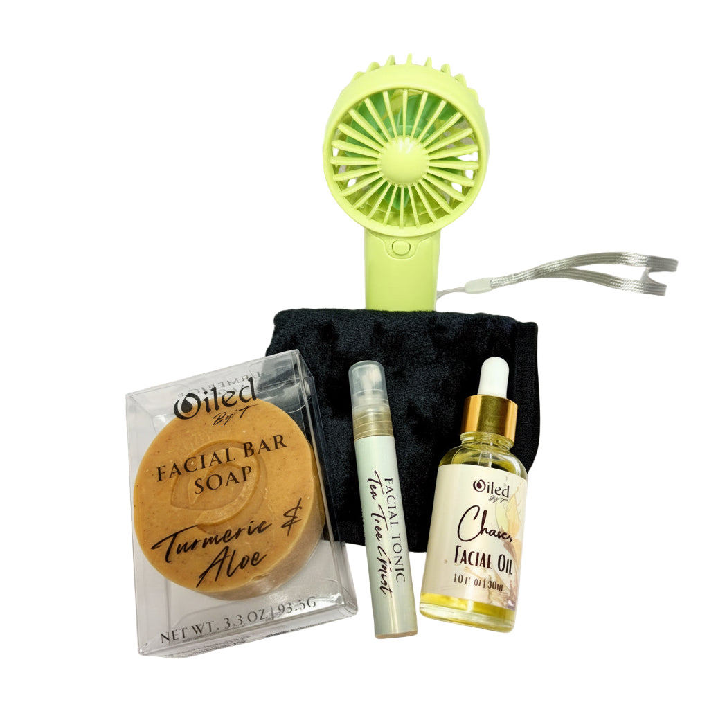 Collection of skincare products including a facial bar soap, serum, and oil with a small fan on a white background.