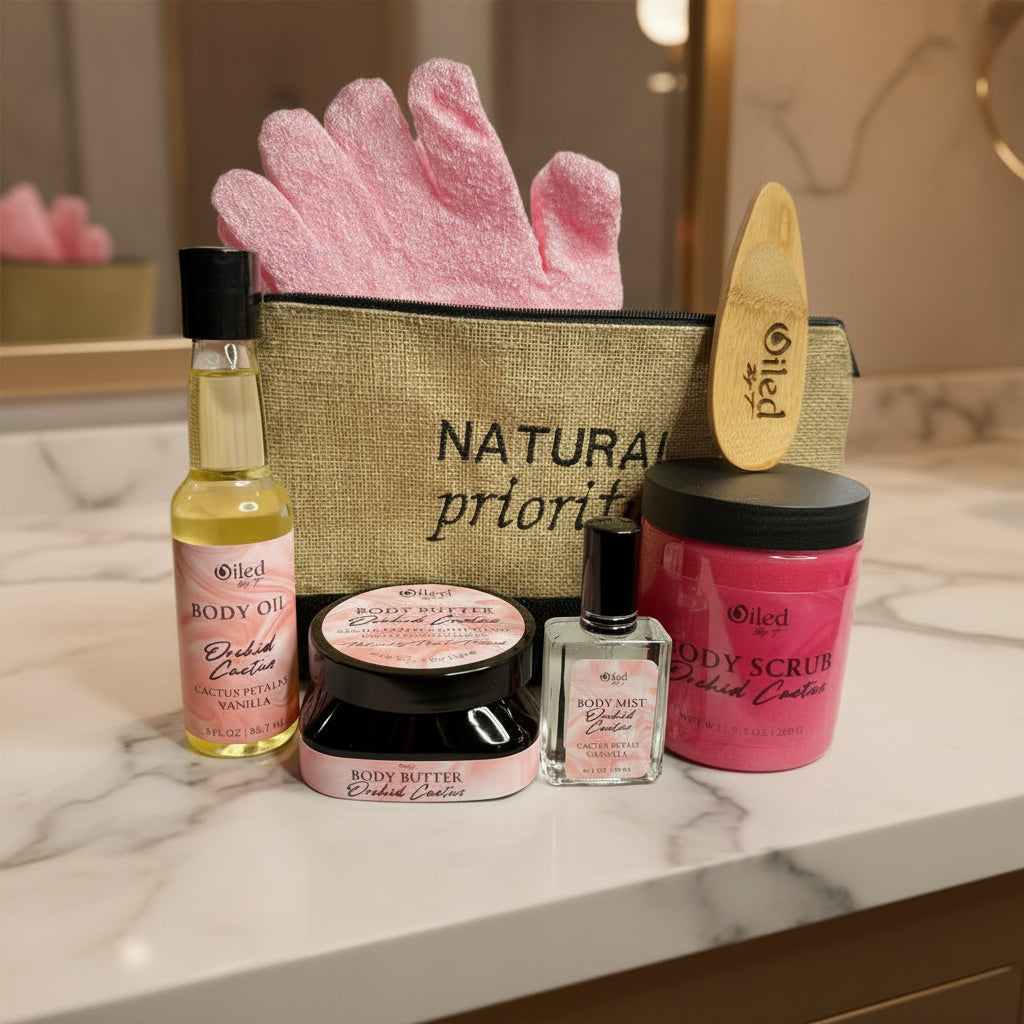 Collection of Oiled body care products including oil, butter, scrub, mist, and glove on a white background.