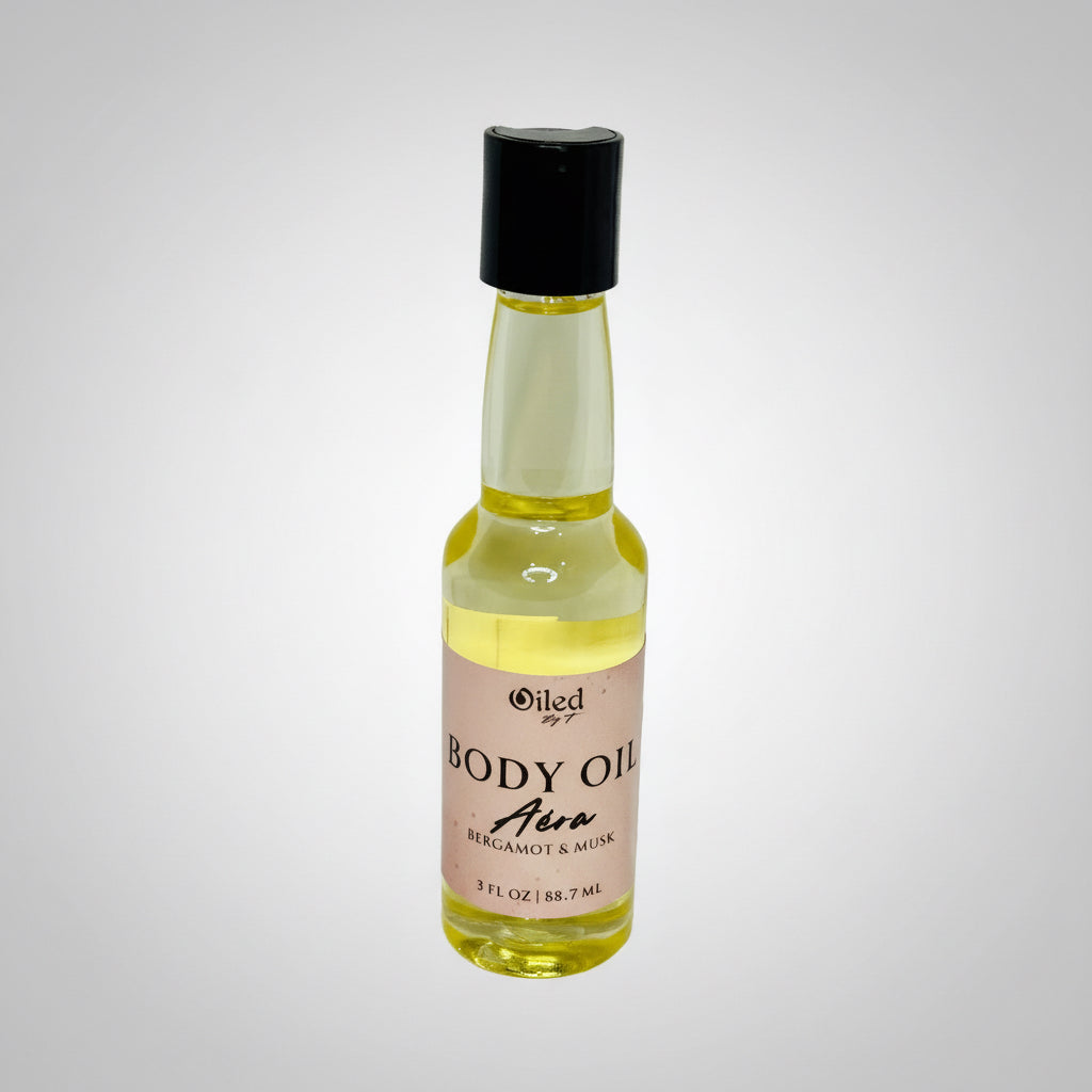 Small bottle of body oil with a black cap on a light gray background